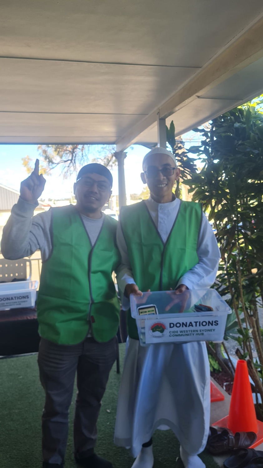 Two volunteers holding the CIDE Western Sydney donations box